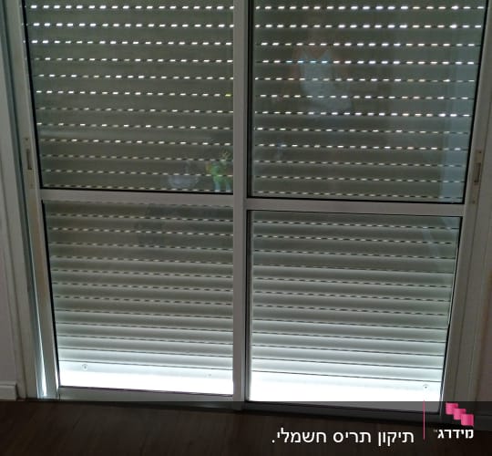 תריסים סגורים עם חריצים לאור על דלת זכוכית
